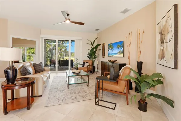 a living room with furniture ceiling fan and a window