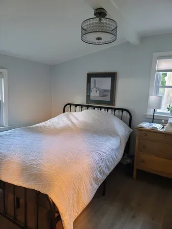 a bedroom with bed and a chandelier