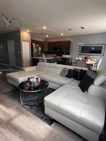 a living room with furniture and kitchen view