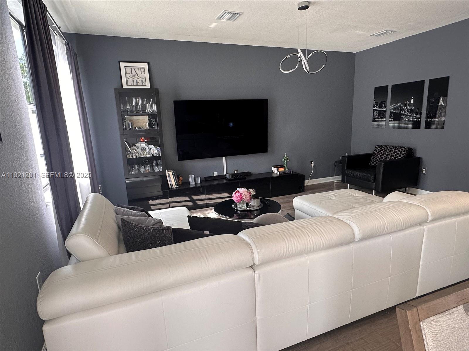 3378 West 100th Terrace, Unit 3378 Hialeah, FL 33018 - Photo 13 of 41 a living room with furniture and a flat screen tv