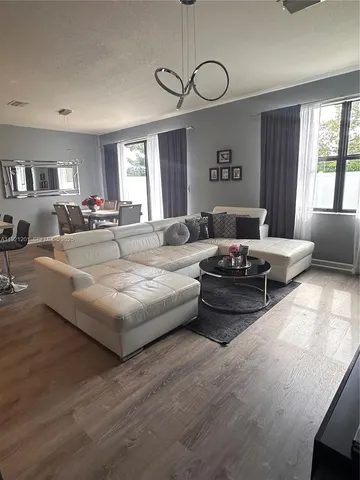 a living room with furniture large window and flat screen tv
