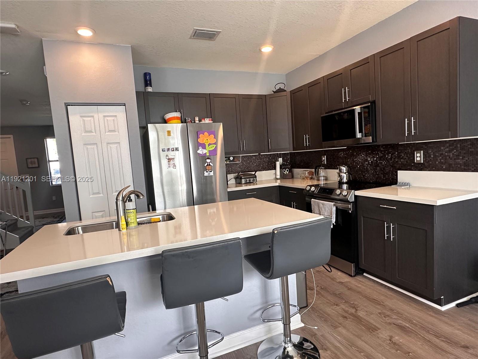 3378 West 100th Terrace, Unit 3378 Hialeah, FL 33018 - Photo 15 of 41 a kitchen with a sink cabinets and wooden floor