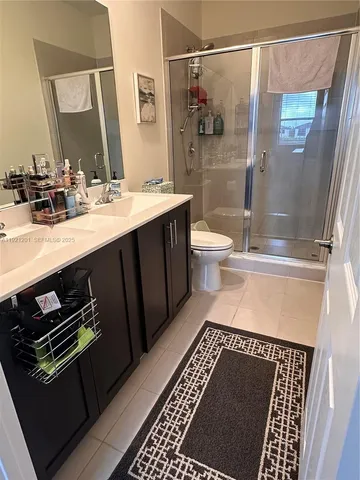 a bathroom with a sink a toilet a mirror and shower
