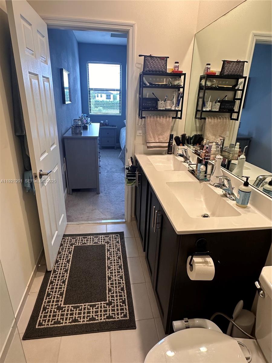 3378 West 100th Terrace, Unit 3378 Hialeah, FL 33018 - Photo 24 of 41 a bathroom with a sink a toilet a mirror and vanity