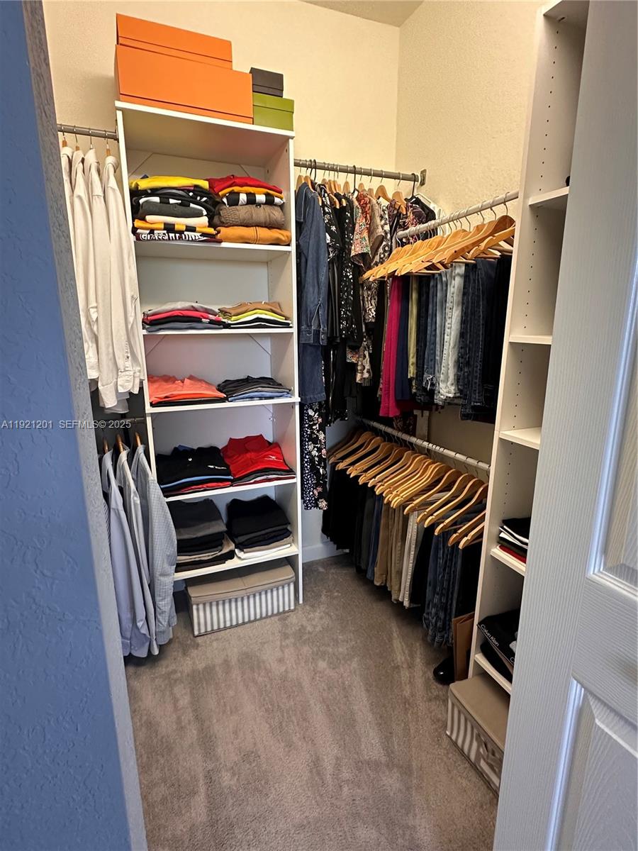 3378 West 100th Terrace, Unit 3378 Hialeah, FL 33018 - Photo 25 of 41 a view of walk in closet with clothes and shoes