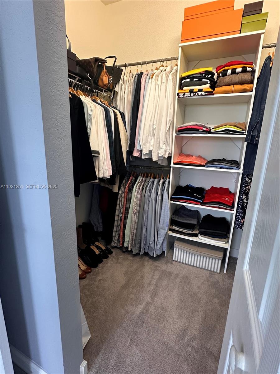 3378 West 100th Terrace, Unit 3378 Hialeah, FL 33018 - Photo 26 of 41 a view of walk in closet with clothes and shoes