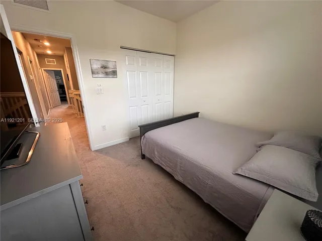 a bedroom with a bed and a flat tv screen on the dresser