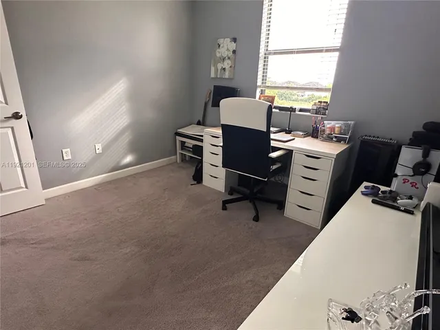 a view of a workspace with furniture and a window