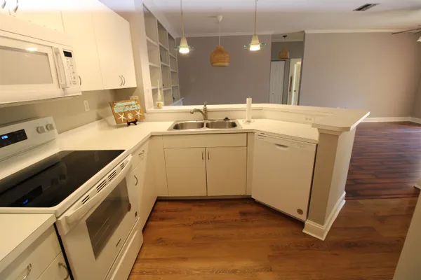 a kitchen with a stove cabinets and wooden floor