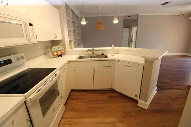 a kitchen with a stove cabinets and wooden floor