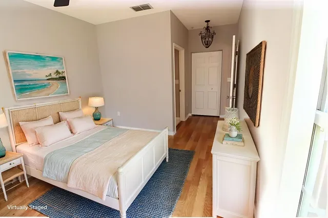 a view of a room with wooden floor and a ceiling fan