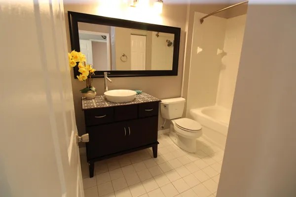 a bathroom with a toilet a sink a mirror and a shower