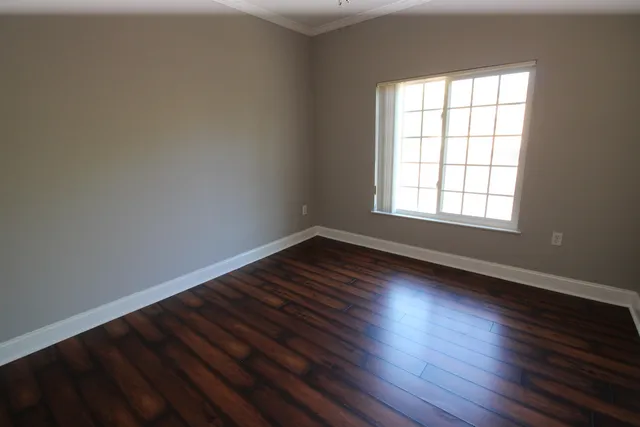an empty room with wooden floor and entrance