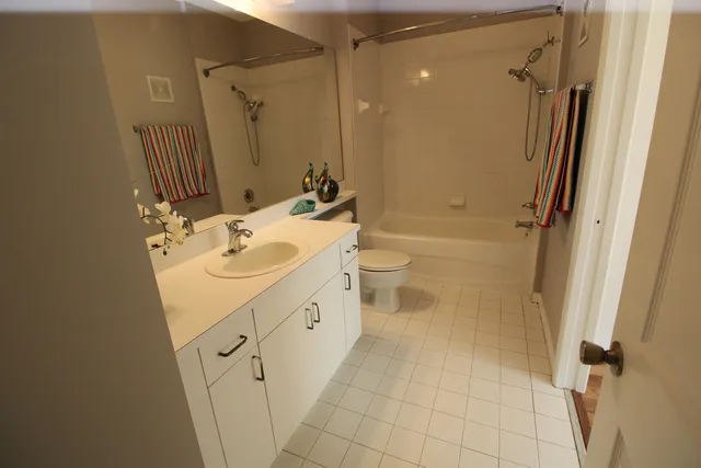 a bathroom with a sink a toilet a mirror and shower