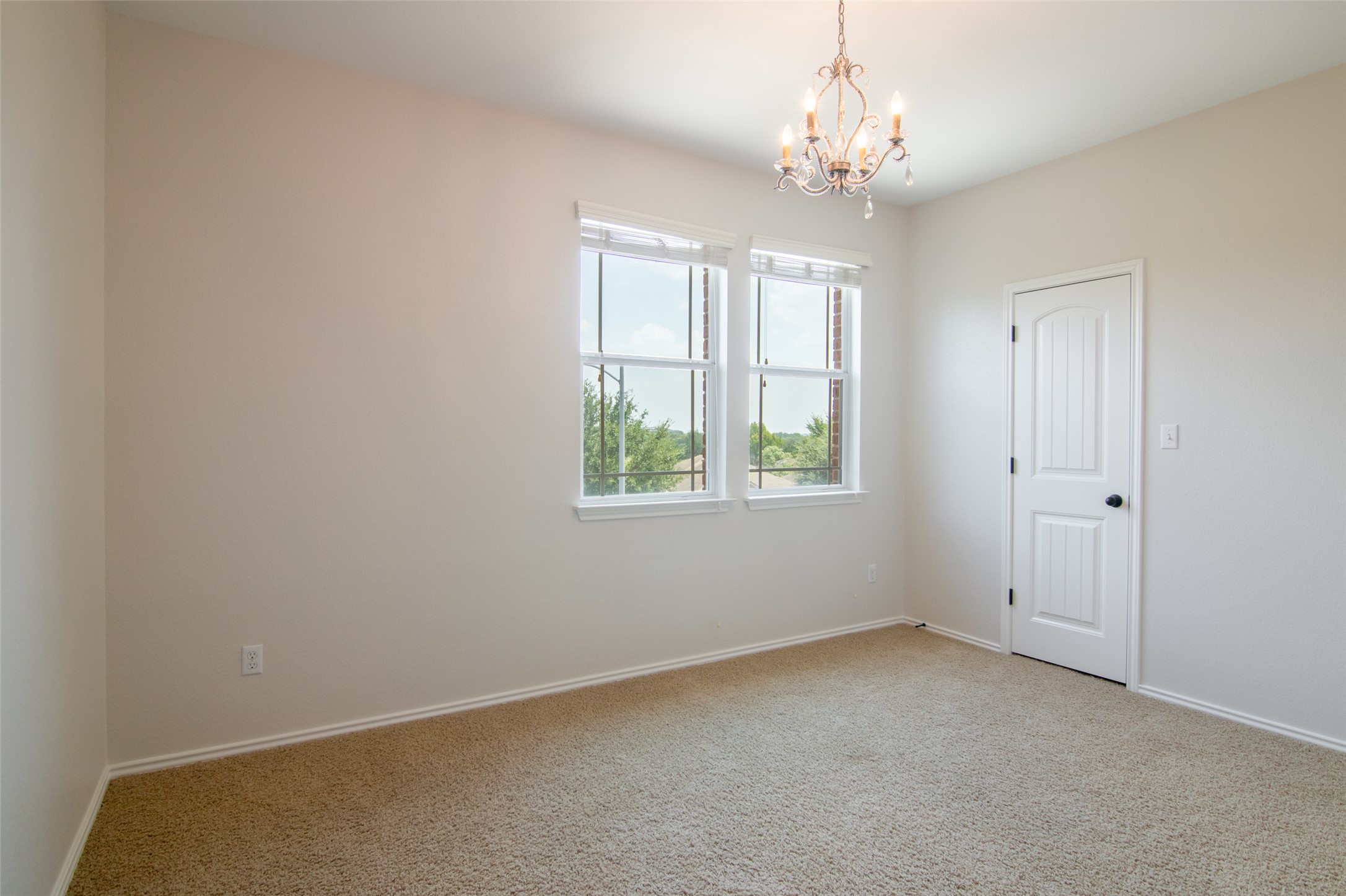 12104 Broten Street Austin, TX 78748 - Photo 24 of 32 A well-lit bedroom provides comfort and features a tasteful chandelier and serene outdoor views.