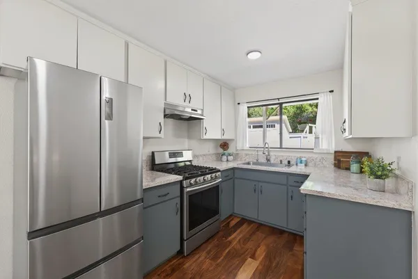 a kitchen with stainless steel appliances a sink stove and refrigerator