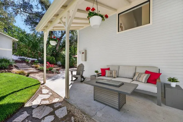 a living room with patio furniture and a garden