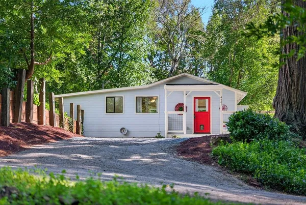 a front view of a house with a yard and trees