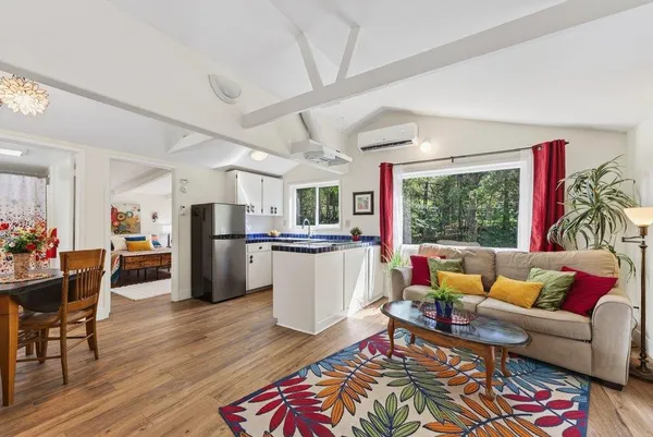 a living room with furniture and a dining table with kitchen view