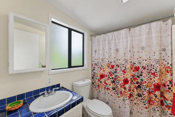a bathroom with a toilet sink and mirror