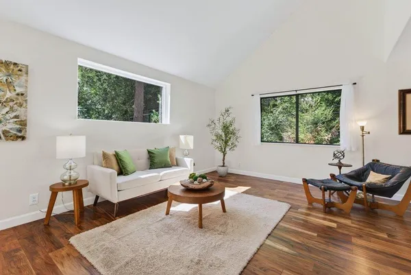 a living room with furniture a rug and a large window