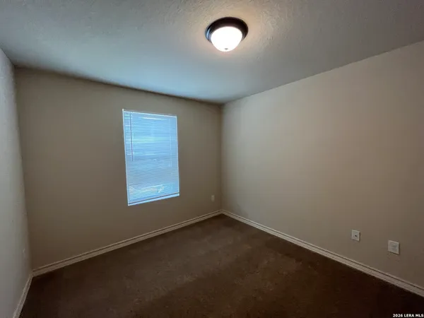 an empty room with a ceiling fan and wooden floor