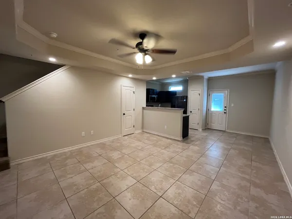 a view of empty room with kitchen and ceiling fan
