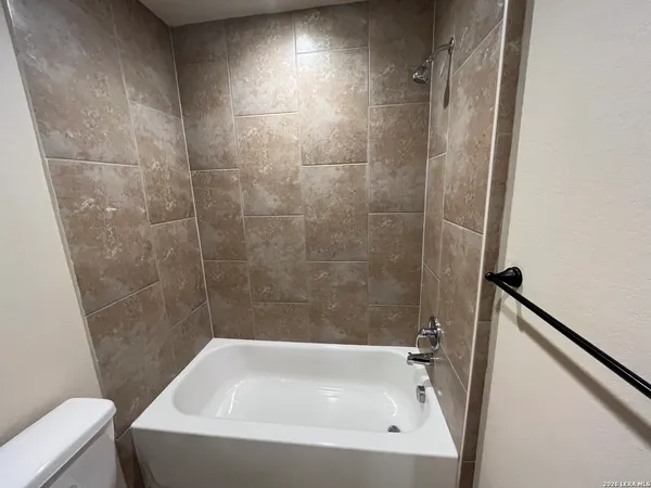 a bathroom with a granite countertop sink and a toilet