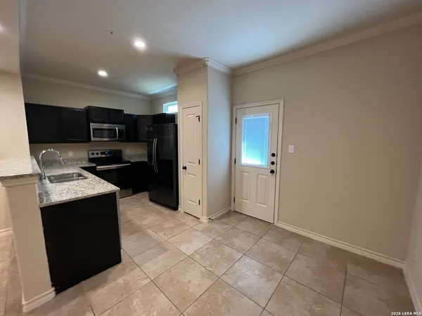 a kitchen with stainless steel appliances granite countertop a refrigerator and a stove top oven