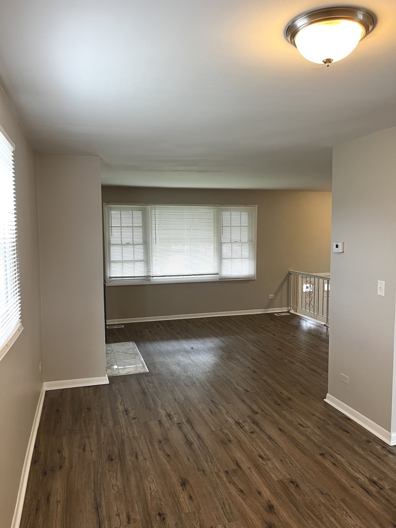 16524 Woodlawn W Avenue South Holland, IL 60473 - Photo 4 of 20 an empty room with wooden floor and windows