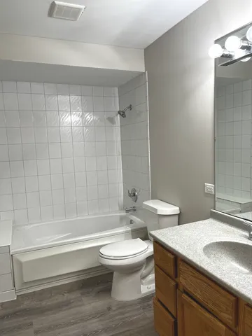 a bathroom with a sink a toilet and a large mirror