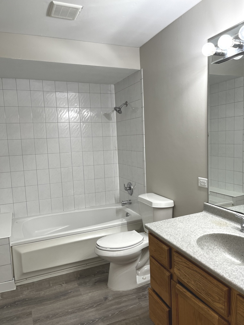 16524 Woodlawn W Avenue South Holland, IL 60473 - Photo 10 of 20 a bathroom with a sink a toilet and a large mirror