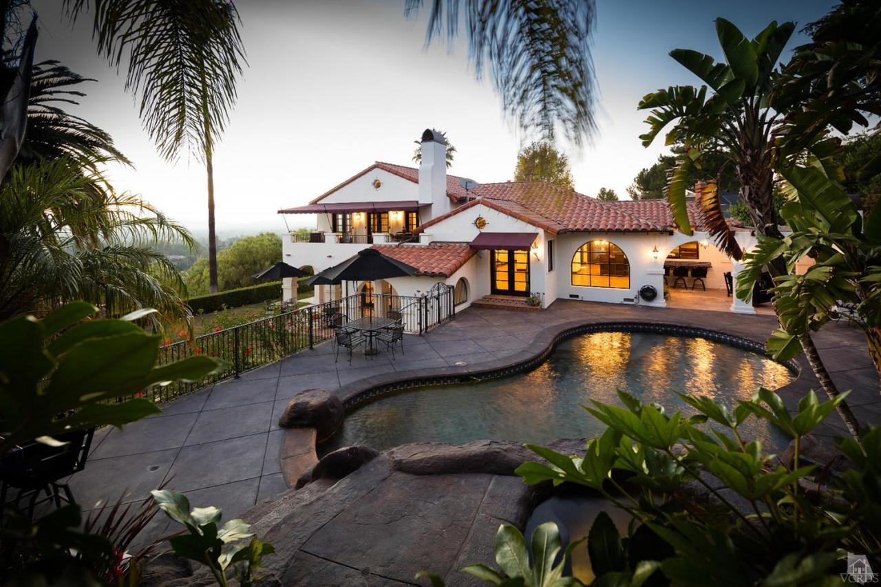 a front view of a house with swimming pool having outdoor seating