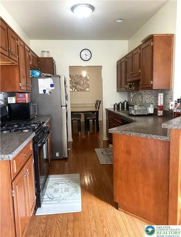 a kitchen with stainless steel appliances granite countertop wooden cabinets a stove top oven a sink and dishwasher