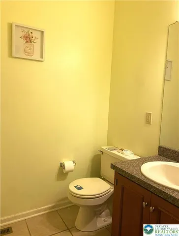 a bathroom with a granite countertop toilet and a sink