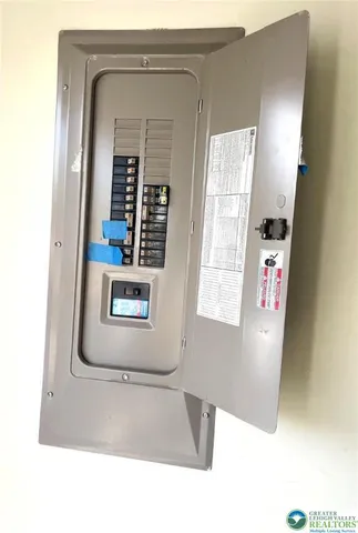 a backyard of a house with table and chairs plants and large tree