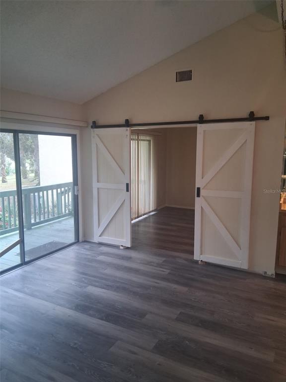 149 Club House Boulevard, Unit 149 New Smyrna Beach, FL 32168 - Photo 19 of 32 an empty room with wooden floor and windows