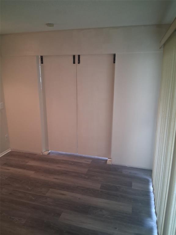 149 Club House Boulevard, Unit 149 New Smyrna Beach, FL 32168 - Photo 21 of 32 a view of an empty room with wooden floor and a window