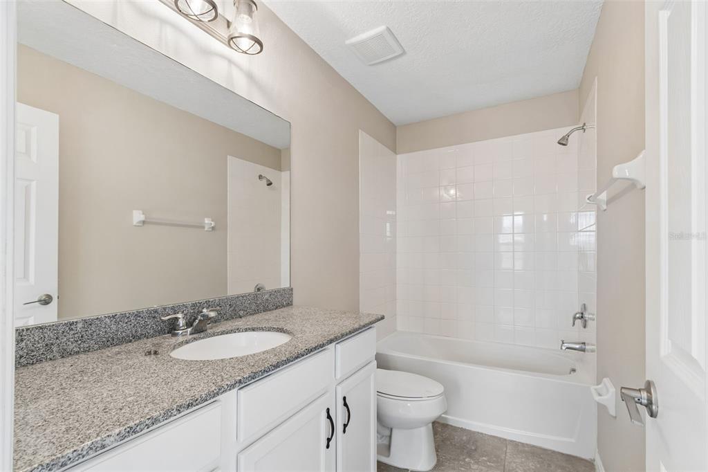 1192 Multiflora Loop Lutz, FL 33558 - Photo 27 of 32 a bathroom with a granite countertop sink toilet and shower