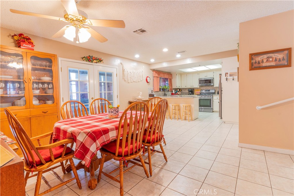 17516 Olive Street Hesperia, CA 92345 - Photo 12 of 32 a dining hall with stainless steel appliances lots of white furniture a dining table and chairs