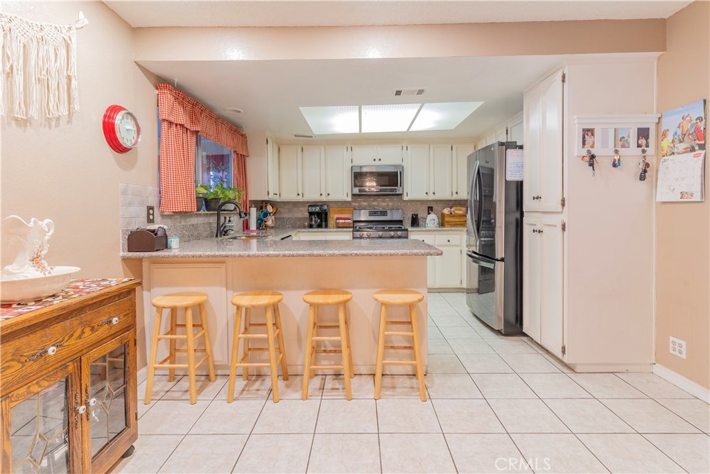 17516 Olive Street Hesperia, CA 92345 - Photo 8 of 32 a kitchen with stainless steel appliances granite countertop a stove a sink and a refrigerator