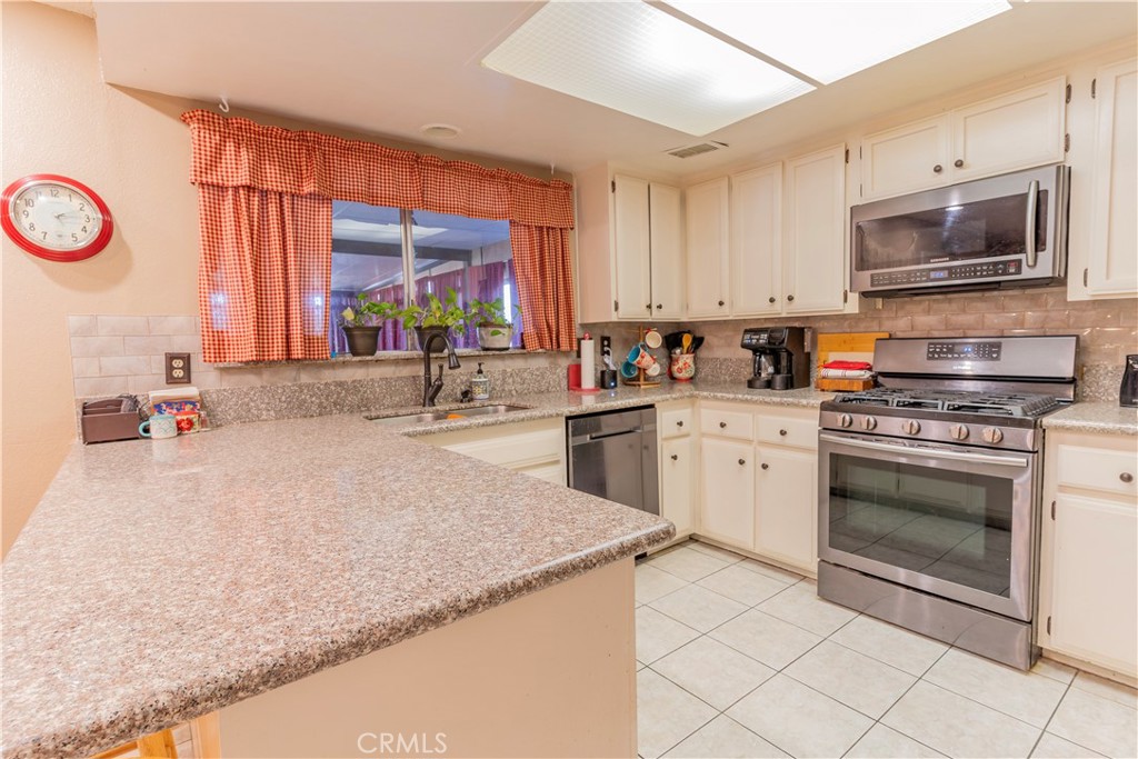 17516 Olive Street Hesperia, CA 92345 - Photo 9 of 32 a kitchen with stainless steel appliances granite countertop a sink and a stove