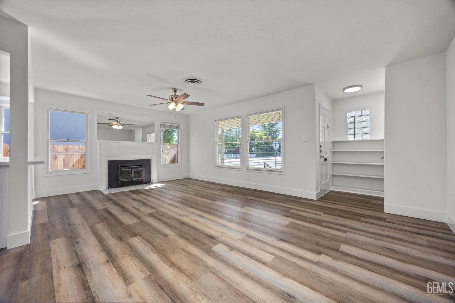 Undisclosed Address Bakersfield, CA 93301 - Photo 11 of 33 wooden floor fireplace and windows in an empty room