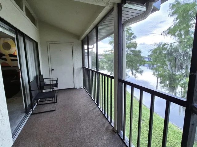 a view of a hallway with wooden floor and stairs