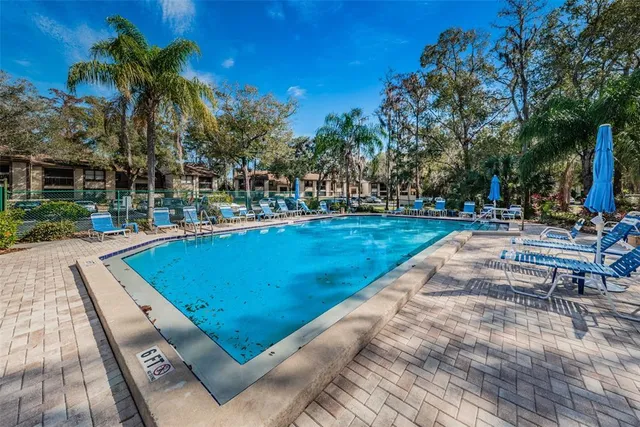 a view of a swimming pool with a patio and a yard