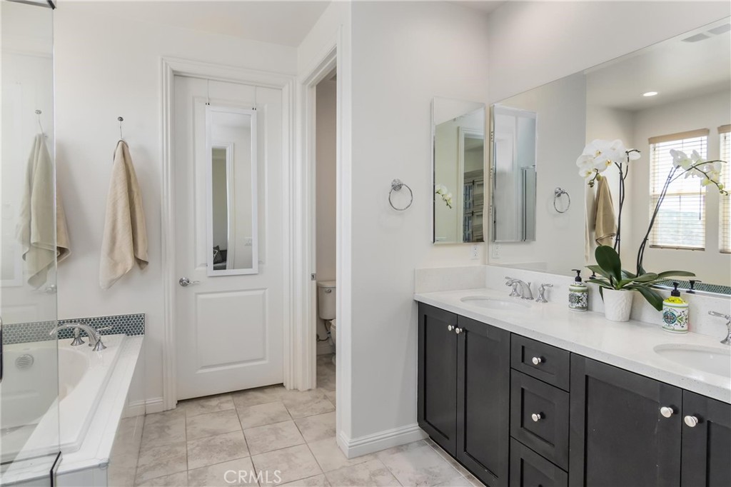 20724 Beech Circle Porter Ranch, CA 91326 - Photo 19 of 27 a bathroom with a double vanity sink a mirror and a bathtub