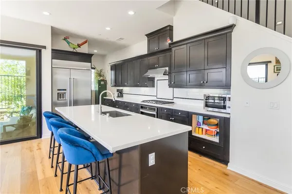 a kitchen with kitchen island a stove and a refrigerator with wooden floor