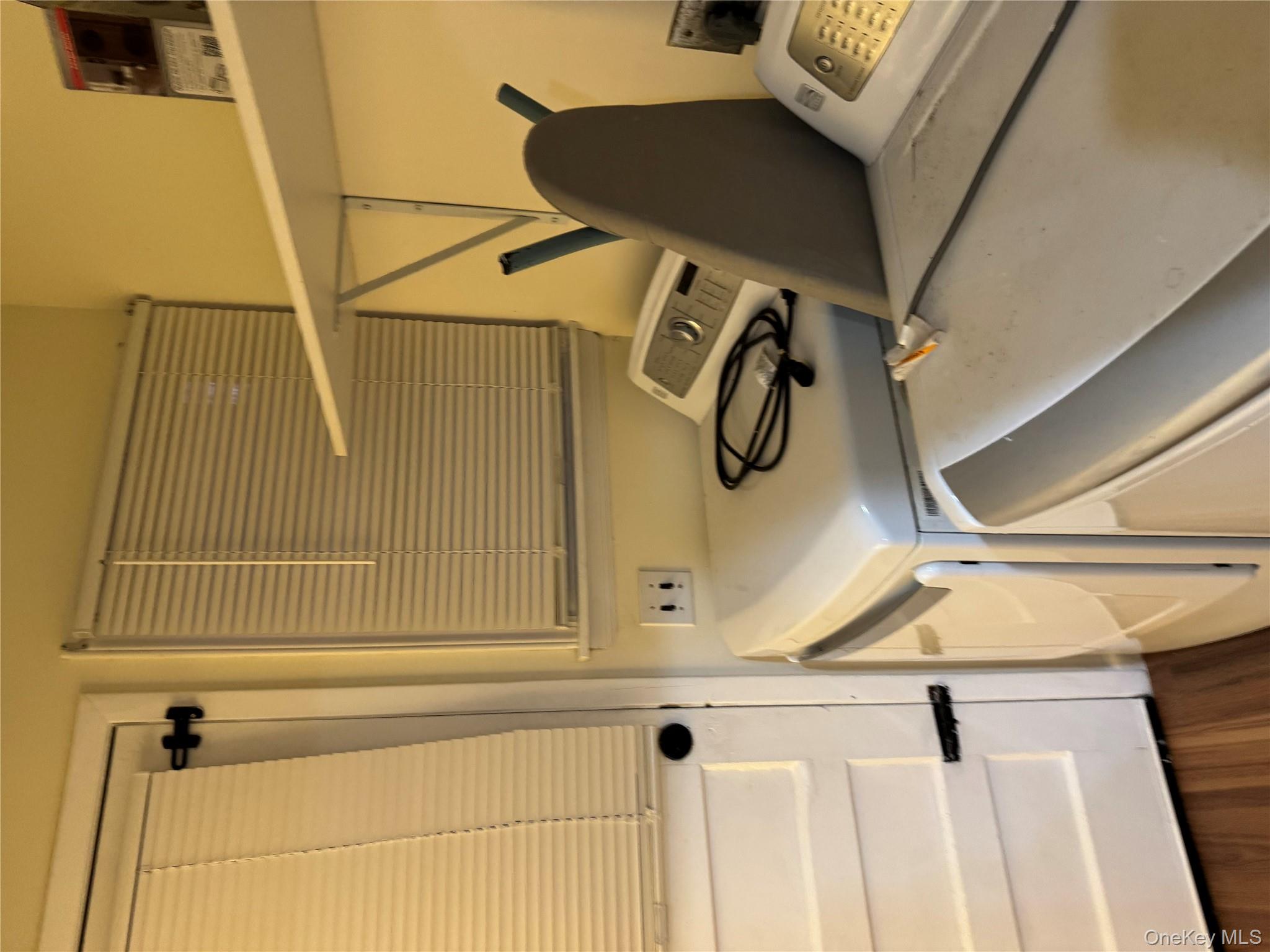 23 Jerome Road Syosset, NY 11791 - Photo 12 of 12 Washroom with washer and dryer and dark wood-type flooring