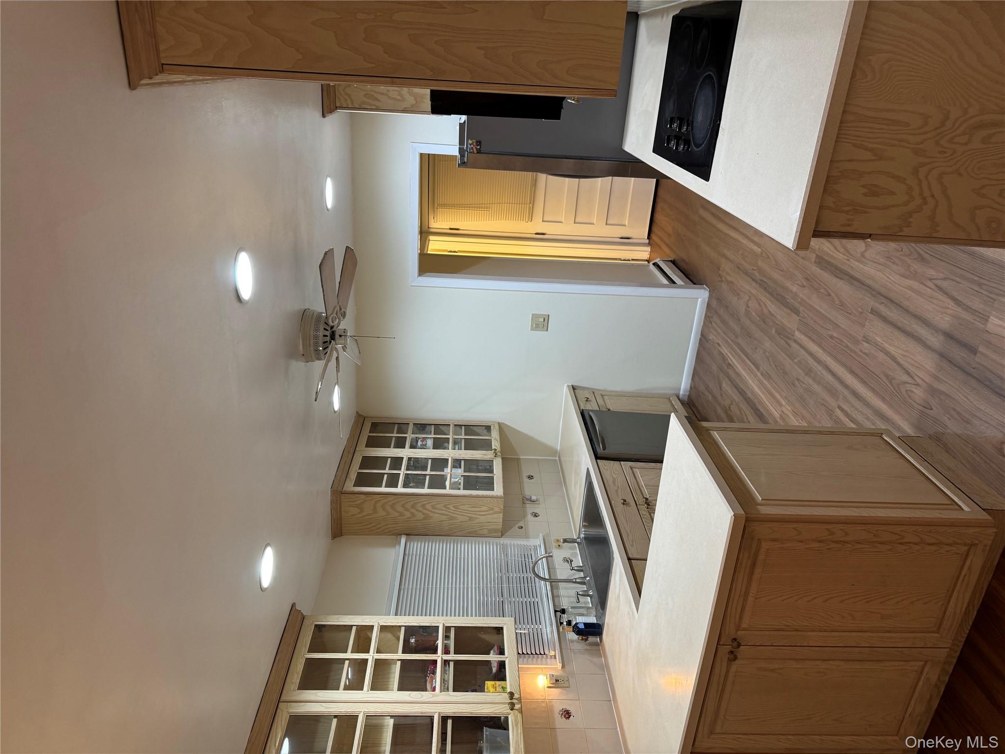 23 Jerome Road Syosset, NY 11791 - Photo 4 of 12 Kitchen with backsplash, a peninsula, light countertops, glass insert cabinets, and cooktop