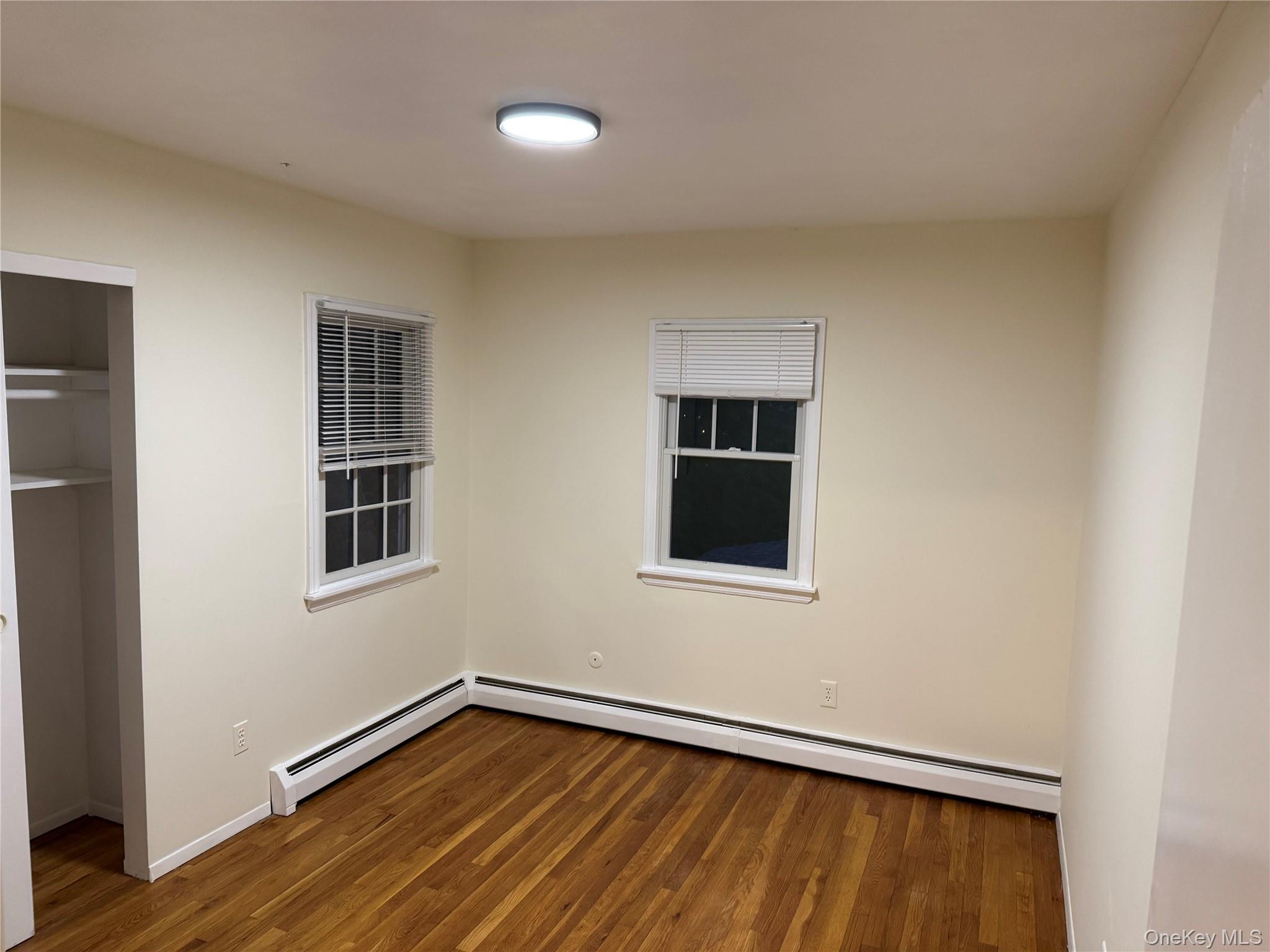 23 Jerome Road Syosset, NY 11791 - Photo 8 of 12 Unfurnished bedroom featuring wood finished floors and a baseboard heating unit